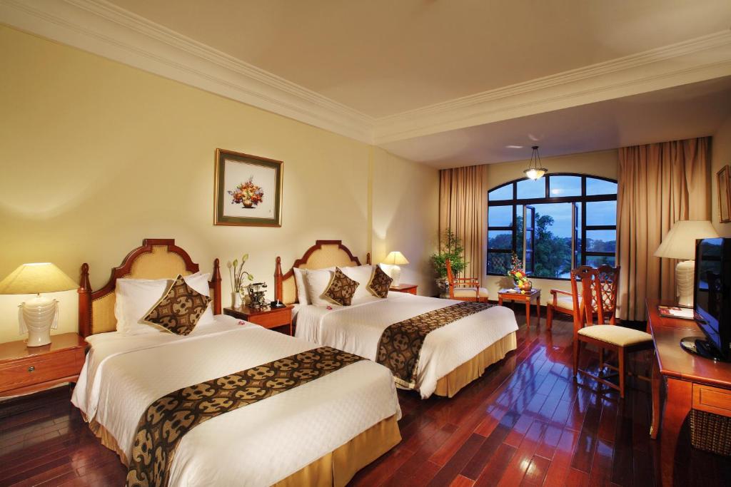 Postel nebo postele na pokoji v ubytování Saigon Morin Hotel