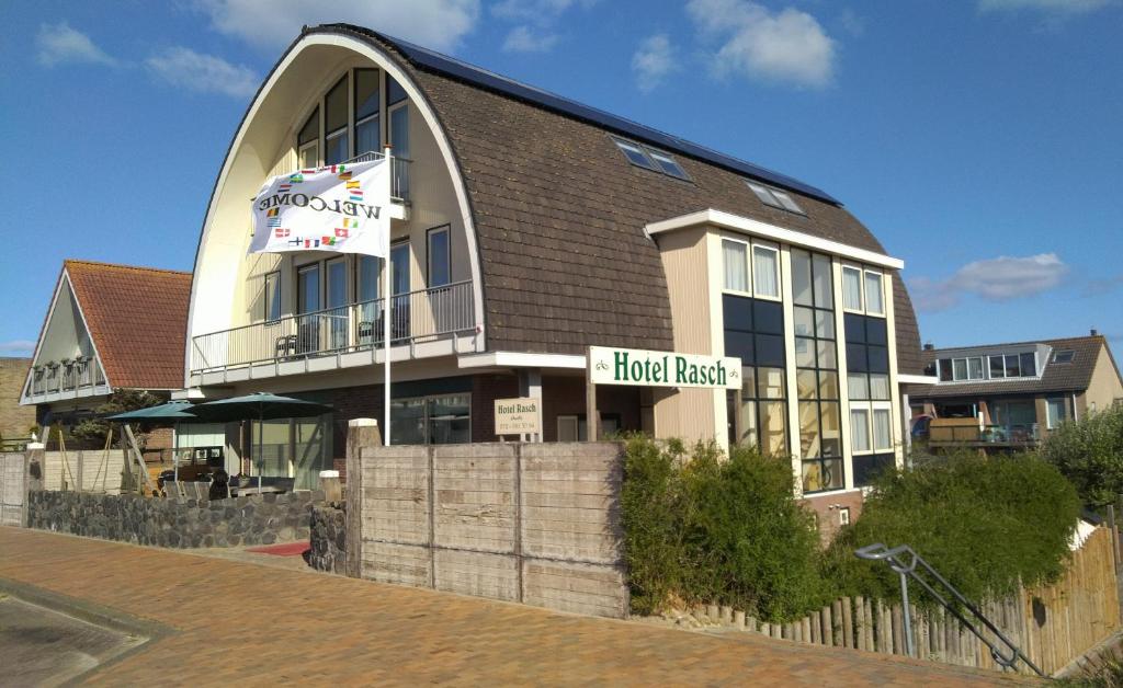 un bâtiment avec un panneau de demande d'hôtel devant lui dans l'établissement Hotel Rasch, à Bergen aan Zee