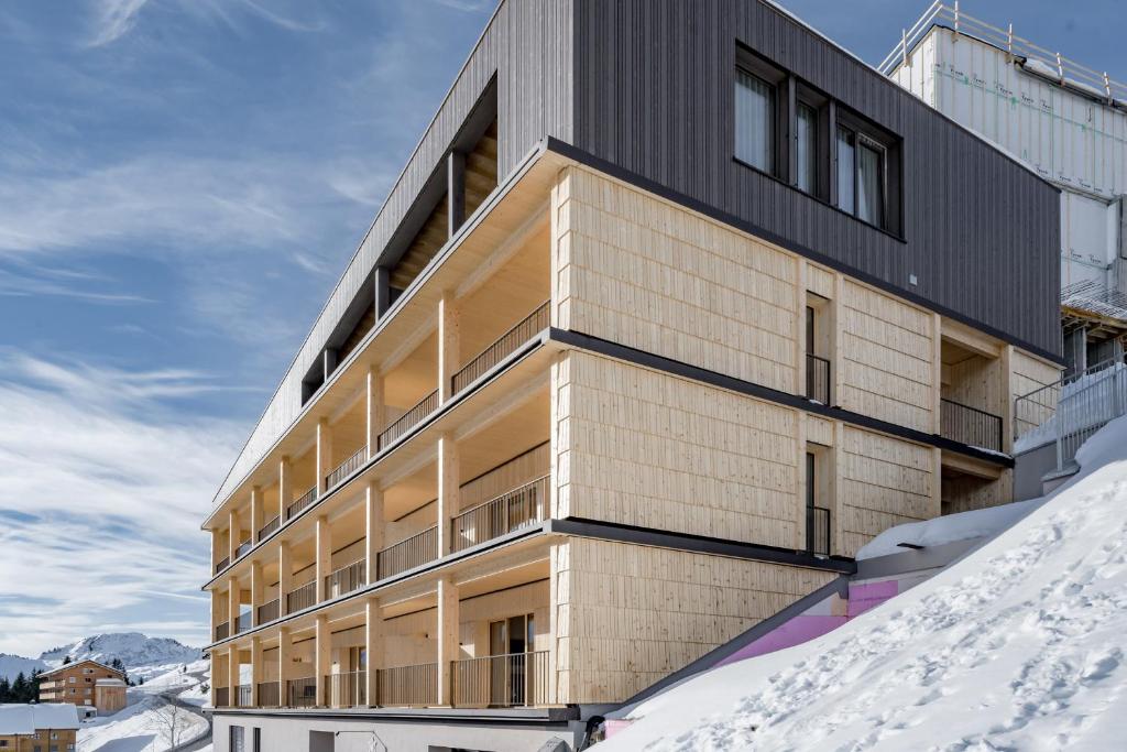 un edificio con nieve delante en Alpenstern Panoramalodge, en Damüls