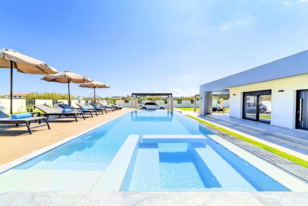 basen z leżakami i parasolami na domu w obiekcie Villa Solaris Heated Pool & Jacuzzi w mieście Georgioupolis