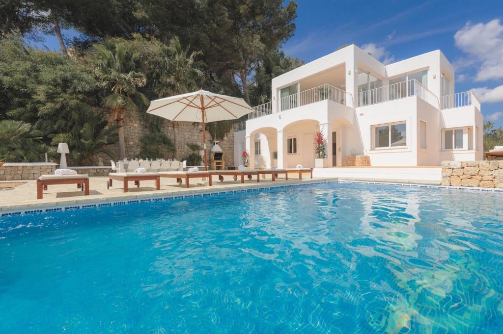 Villa con piscina frente a una casa en Rent this Luxury Villa with Amazing Sea Views, Ibiza Villa 1021, en Sant Josep de sa Talaia