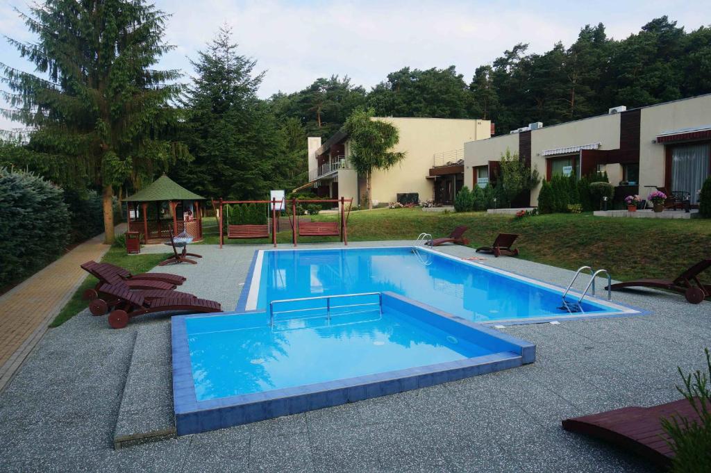 a large swimming pool with blue water in a yard at Studio Wisełka Leśna in Wisełka