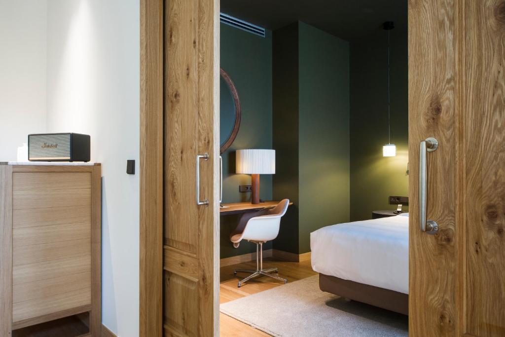 a bedroom with a bed and a dresser at Hotel Arbaso in San Sebastián