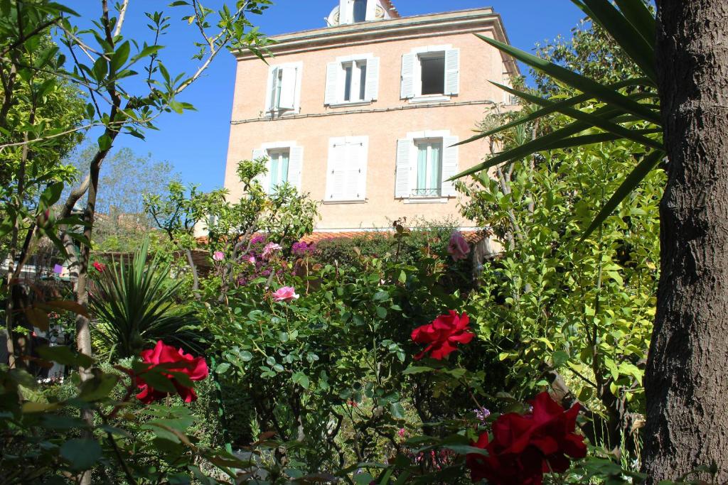 um edifício com um ramo de flores à frente dele em Hôtel Les Palmiers em Saint-Tropez