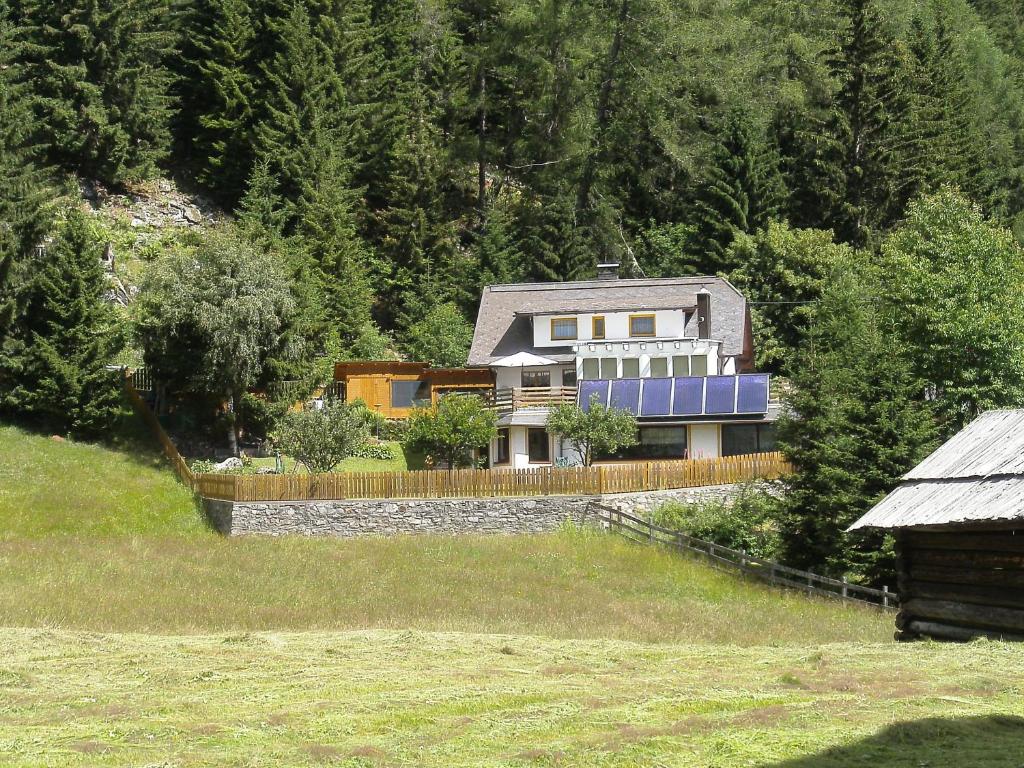 una casa grande en una colina con una valla en Haus Cornelia, en Mallnitz