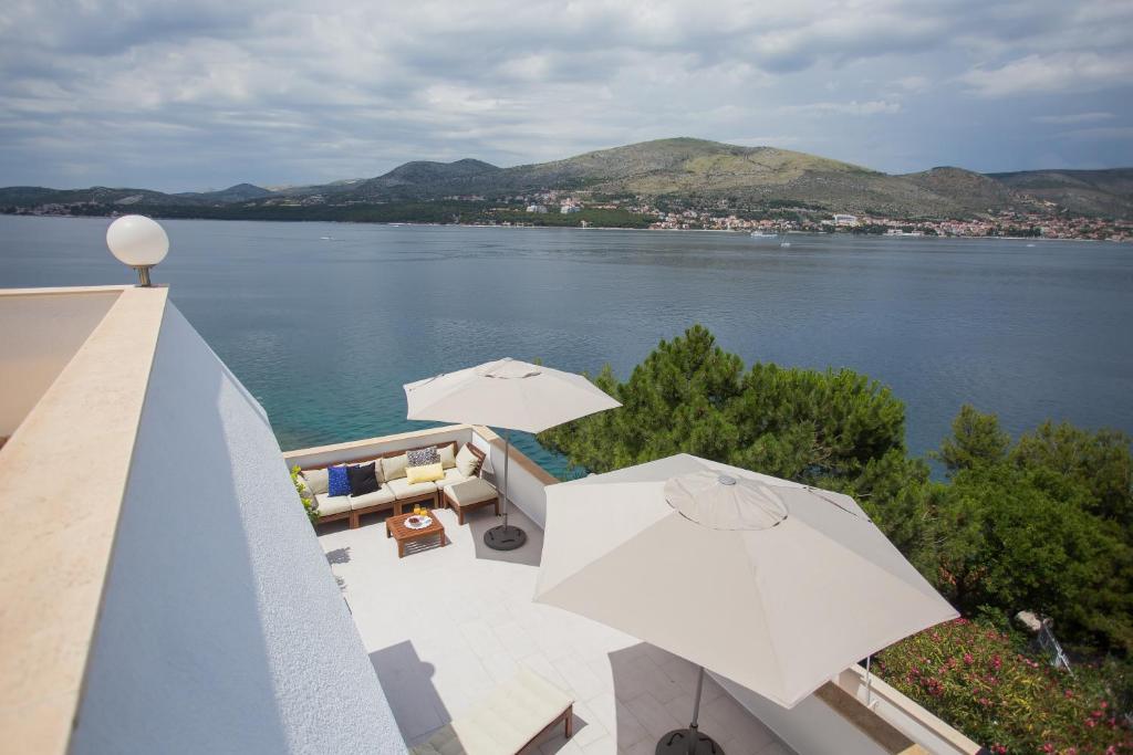 een balkon met parasols en uitzicht op een meer bij Guest House Blanka in Trogir