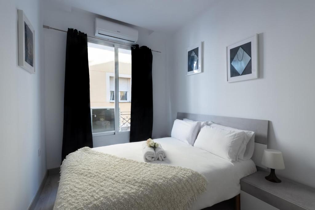 Una cama blanca con un animal de peluche sentado encima. en Apartamentos Day Madrid NOVICIADO Centro Gran Via Sol Malasaña, en Madrid