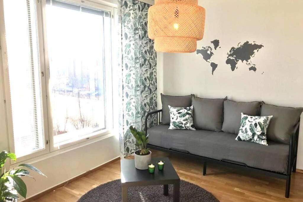 una sala de estar con sofá y un mapa mundial en la pared en Casa Verde nearby Helsinki airport en Vantaa