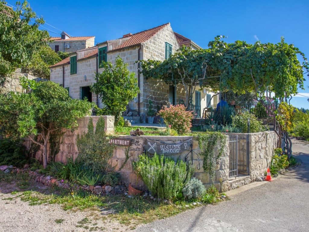 ein Haus mit einem Steinzaun davor in der Unterkunft Country House Bakicevo in Čilipi