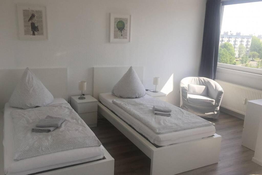 1 Schlafzimmer mit 2 Betten, einem Stuhl und einem Fenster in der Unterkunft Komplett ausgestattetes Apartment in Dormagen in Dormagen