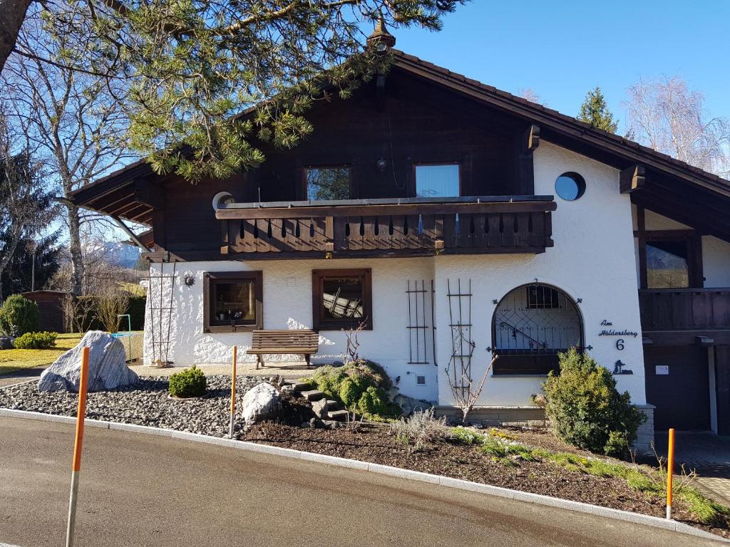 a white building with a balcony on the side of it at Ferienhaus am Höldersberg in Sonthofen