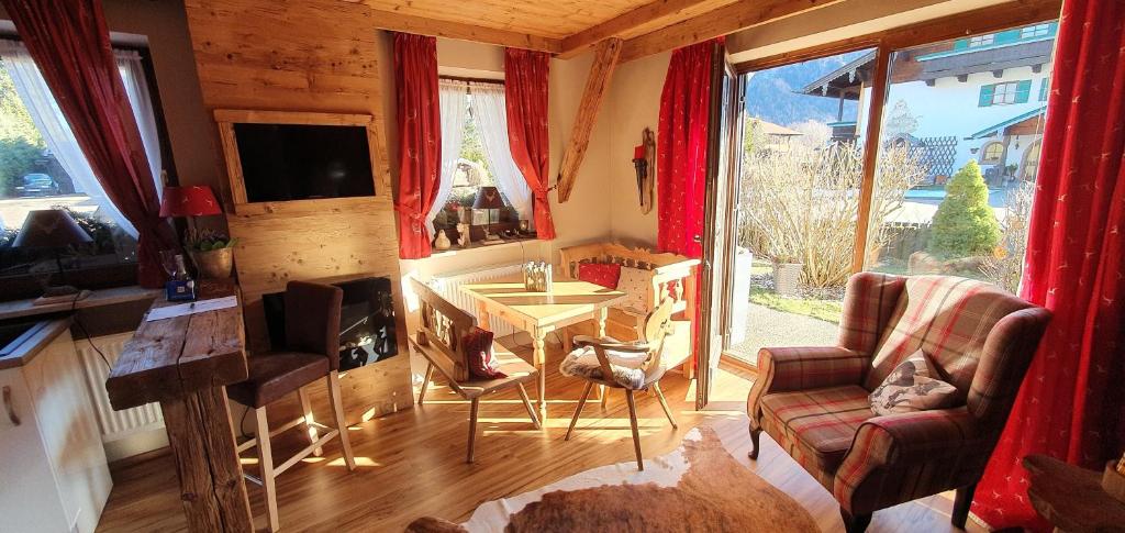 uma sala de estar com um sofá, uma mesa e uma televisão em Chalet Alpenblick Inzell em Inzell
