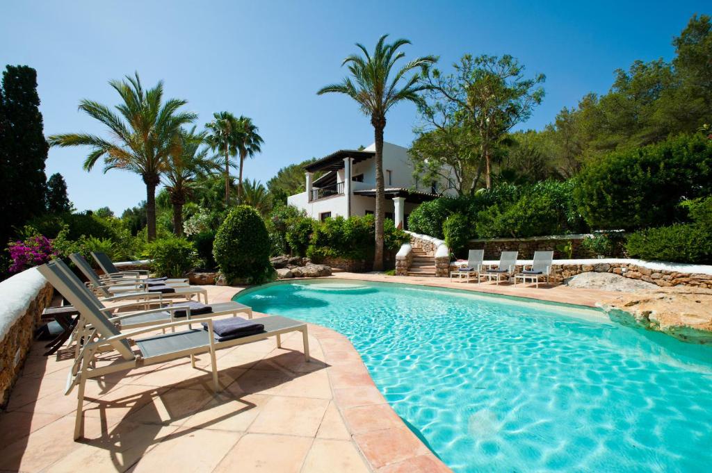una piscina con tumbonas y una casa en Luxury Private Holiday Villa with Private Pool, Ibiza Villa 1077, en Santa Eulària des Riu