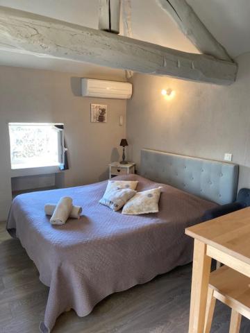 a bedroom with a bed with two pillows on it at Petit studio Le Pigeonnier à 5 mn de Lourmarin in Puyvert