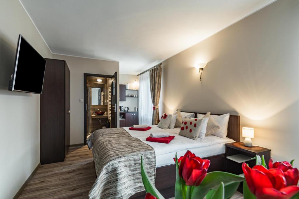 a hotel room with a bed and red flowers at Pieninski Mak. in Szczawnica