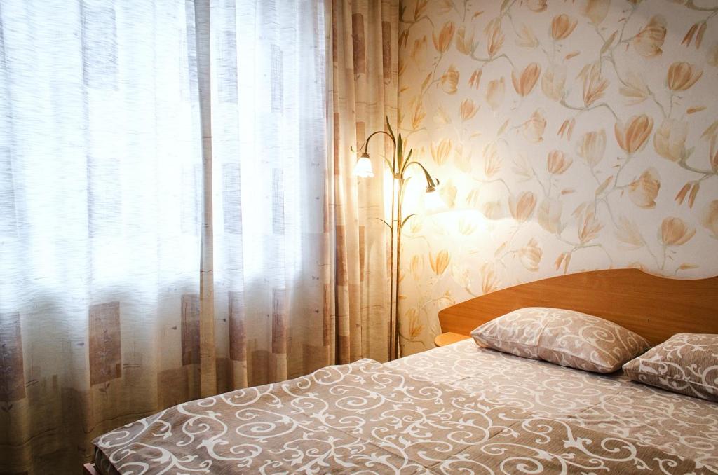 een slaapkamer met een bed en een raam bij Pobedy avenue in Charkov