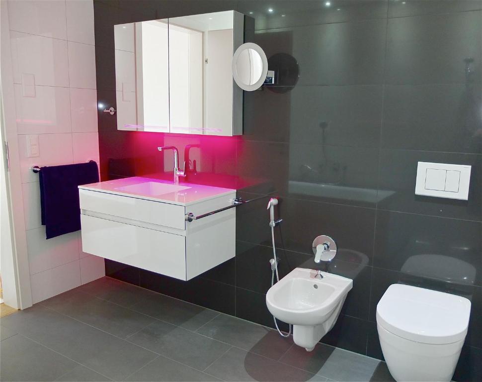 y baño con lavabo rosa y aseo. en Scarlett, en Davos