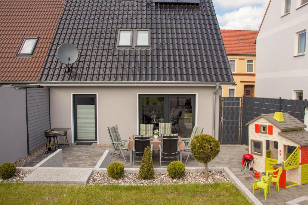 ein Haus mit einem Hinterhof mit einem Tisch und Stühlen in der Unterkunft Familienfreundliches Ferienhaus in Kröpelin in Kröpelin