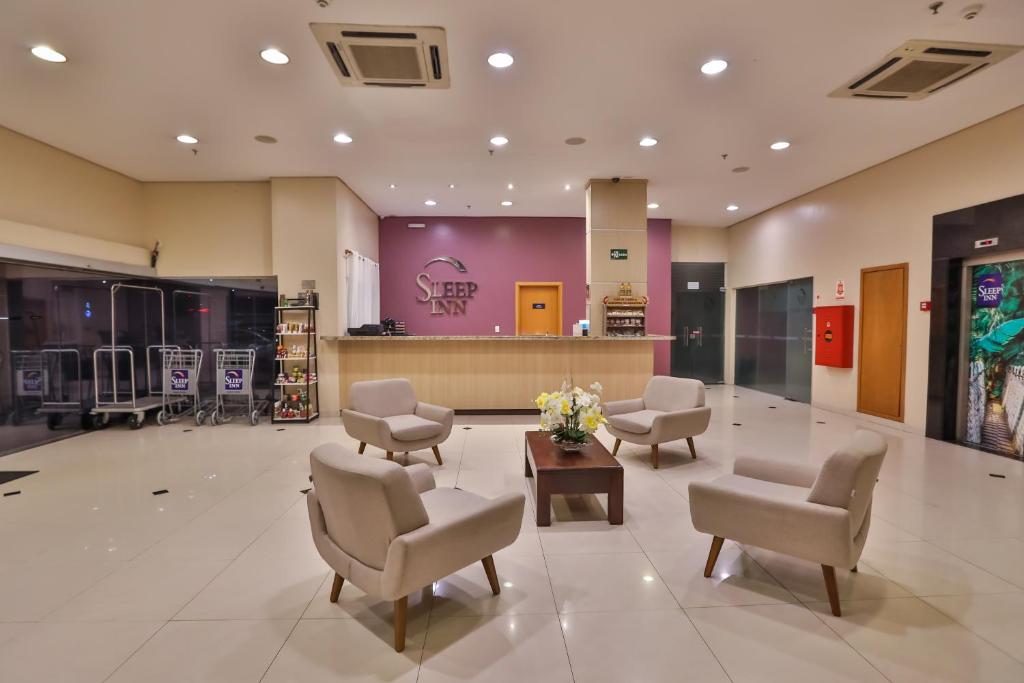 a lobby with a waiting room with chairs and flowers at Sleep Inn Manaus in Manaus