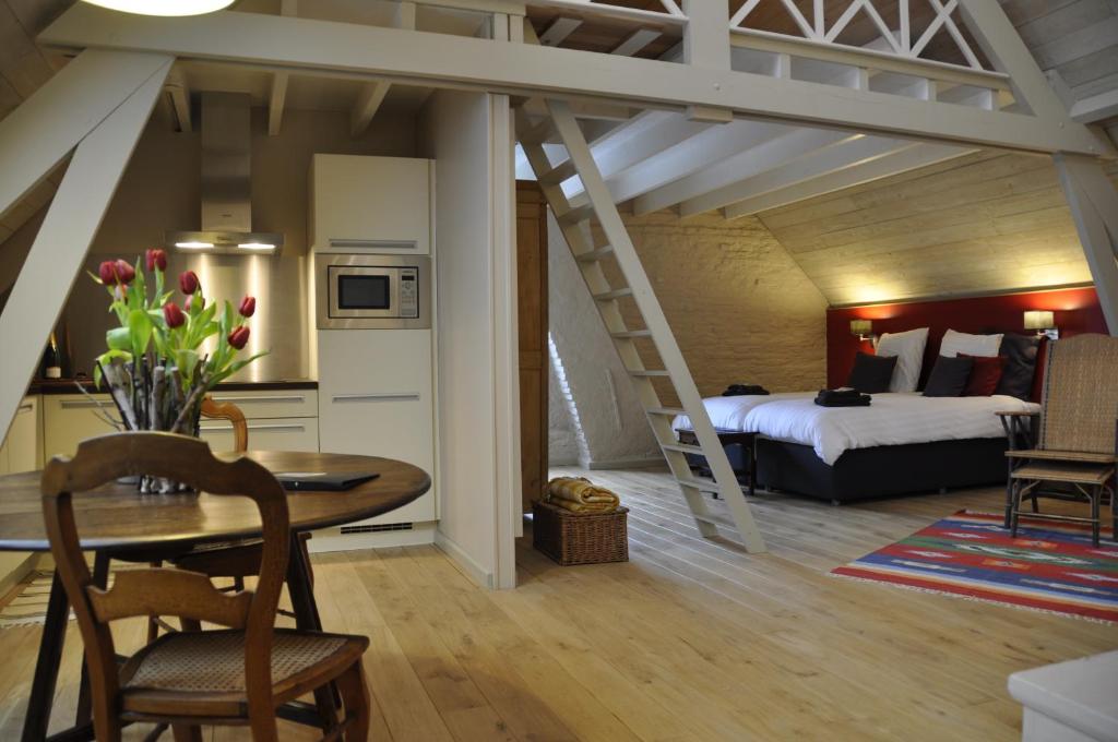 a room with a bed and a dining table and a bedroom at B&B 't Huys van Enaeme in Oudenaarde