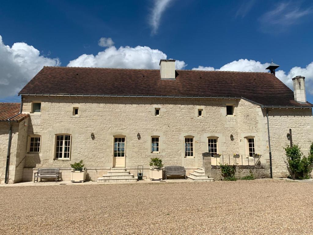 ein großes weißes Backsteingebäude mit braunem Dach in der Unterkunft Farmhouse in a working winery with vineyard views in Marigny-Brizay