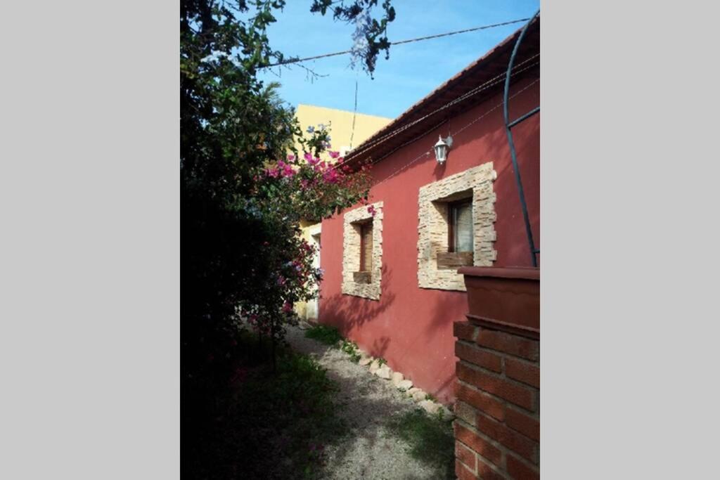 una casa roja con un camino junto a un edificio en Casa Playa los Percheles, en Puerto de Mazarrón