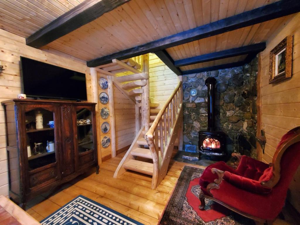a room with a staircase and a fireplace in a log cabin at На Галіції in Kichera