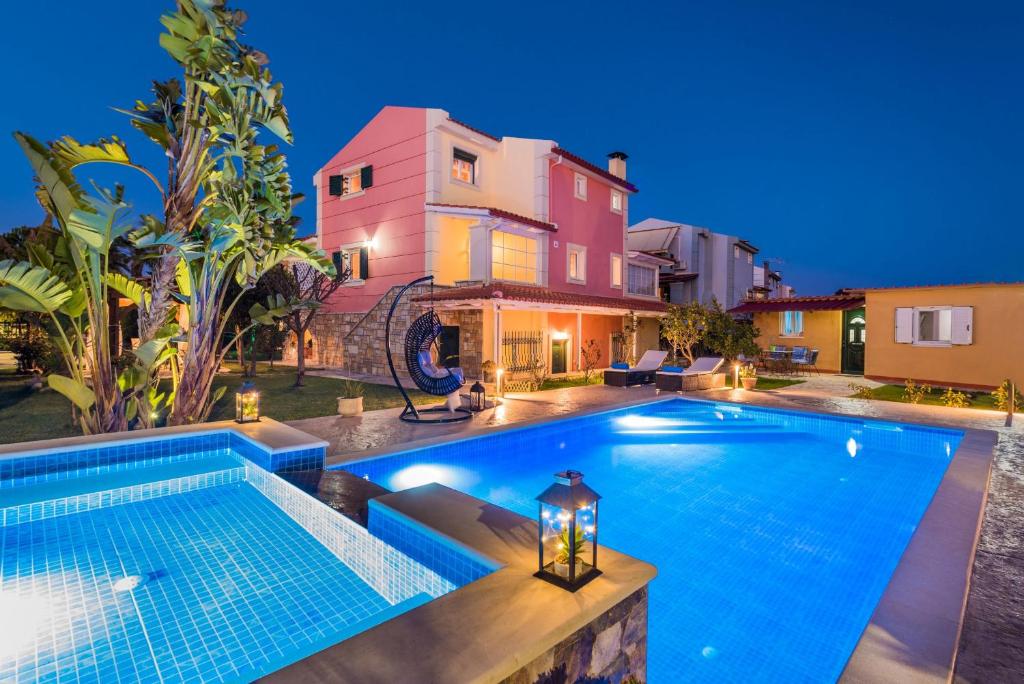 a villa with a swimming pool at night at Villa Garden Star in Zakynthos Town
