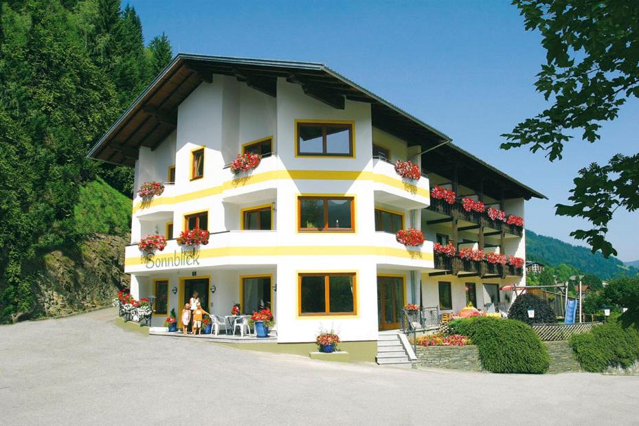 a large white building with people standing outside of it at Hotel Garni Sonnblick in Bad Kleinkirchheim
