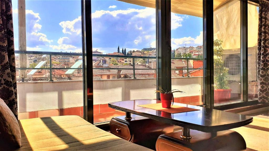 a room with a table in front of a large window at Sunny Days - Park Apartment in Sandanski