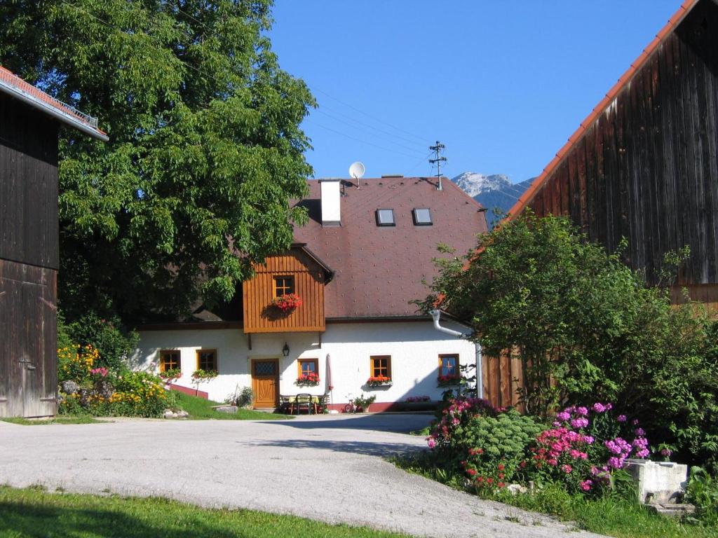 uma casa com uma cerca e flores à frente dela em Gästehof Annerl em Rossleithen