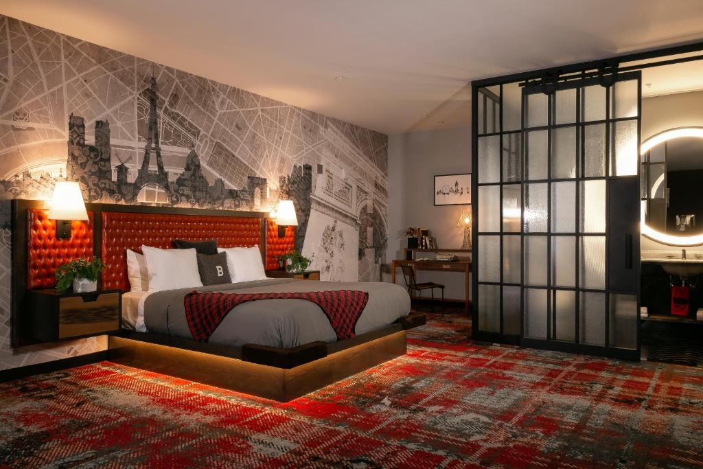 a bedroom with a king sized bed and a wall mural at Bobby Hotel in Nashville