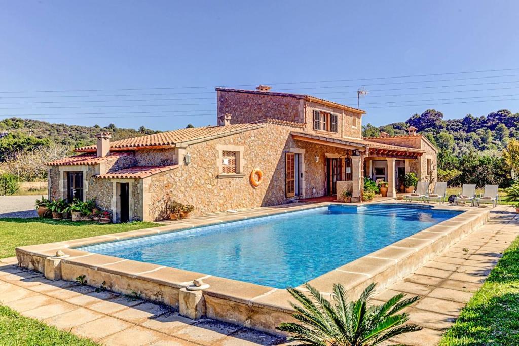 a villa with a swimming pool in front of a house at Can Seguinot Mercer in El Port