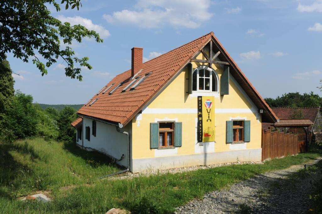 une petite maison jaune avec un toit rouge dans l'établissement Stilvolles Landhaus im Dreiländereck, à Felsőszölnök