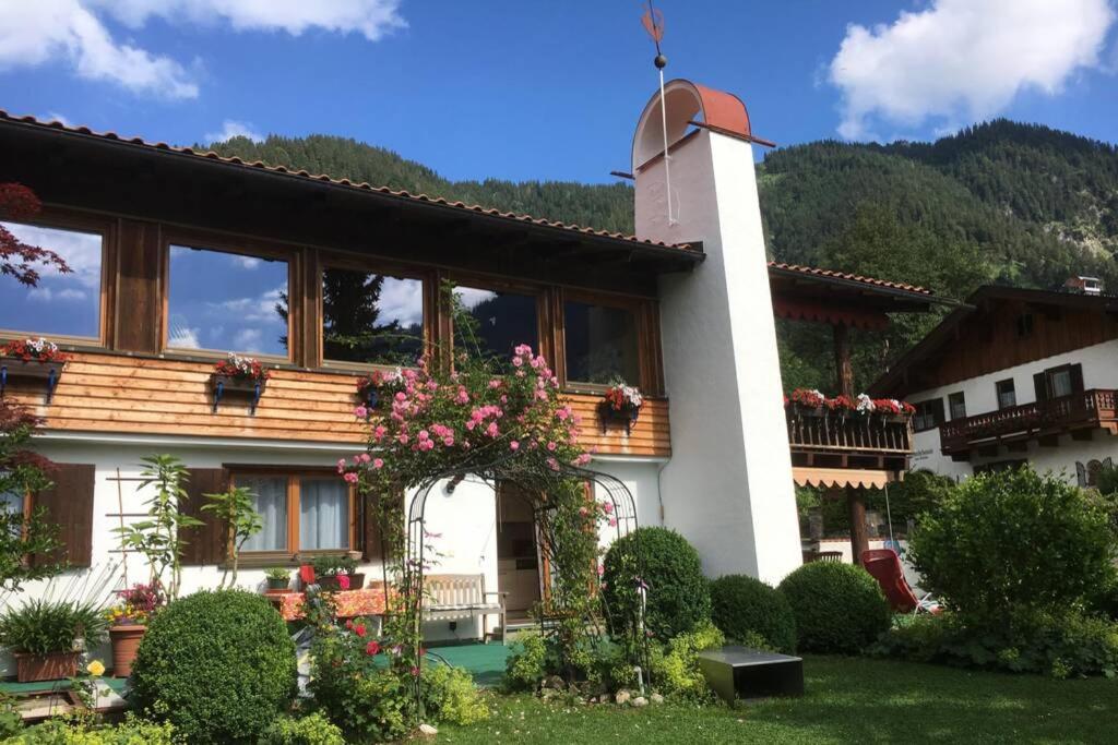 une maison avec beaucoup de fenêtres et de fleurs sur elle dans l'établissement Landhaus Renata Bayrischzell, à Bayrischzell