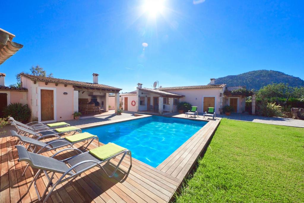 a swimming pool with chairs and a house at Villa Fullos by Sealand Villas in Pollença