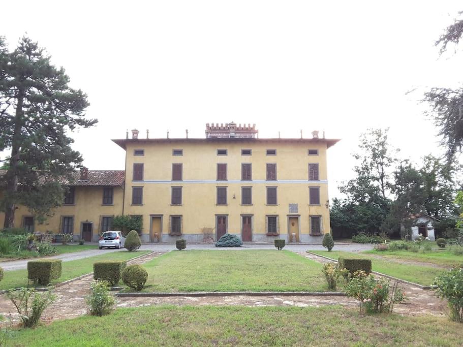 un gran edificio con un coche aparcado delante de él en Cadepaoli Vineyard & Roses - Bergamo Countryside, en Palosco