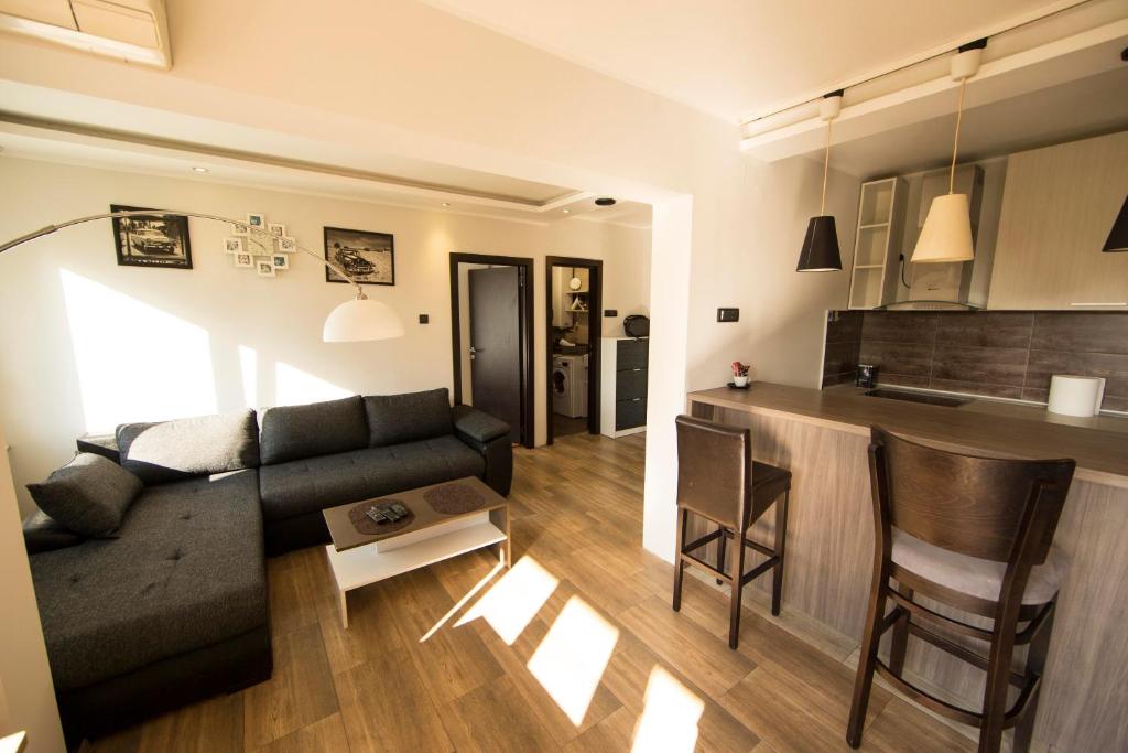 a living room with a couch and a kitchen at Ahoy Belgrade Luxury Apartment in Belgrade