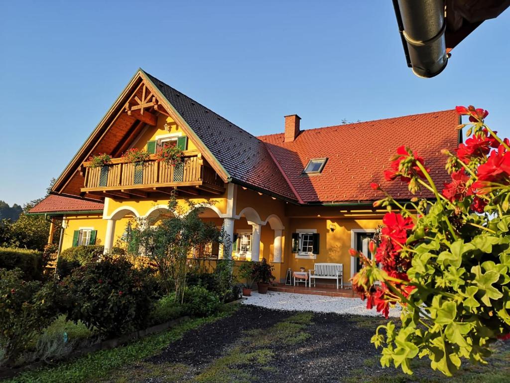 a large yellow house with a red roof at Weingut - Ferienhaus Sonja Rohrbacher in Gamlitz