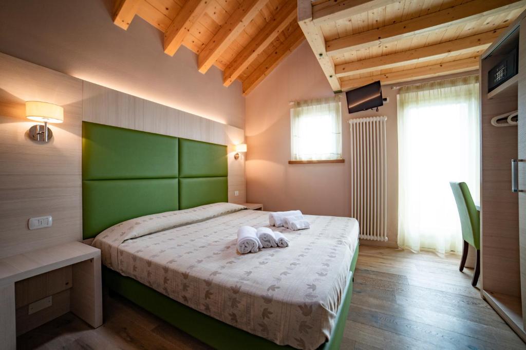 een slaapkamer met een bed met twee handdoeken erop bij Malga Zebari in Velo Veronese