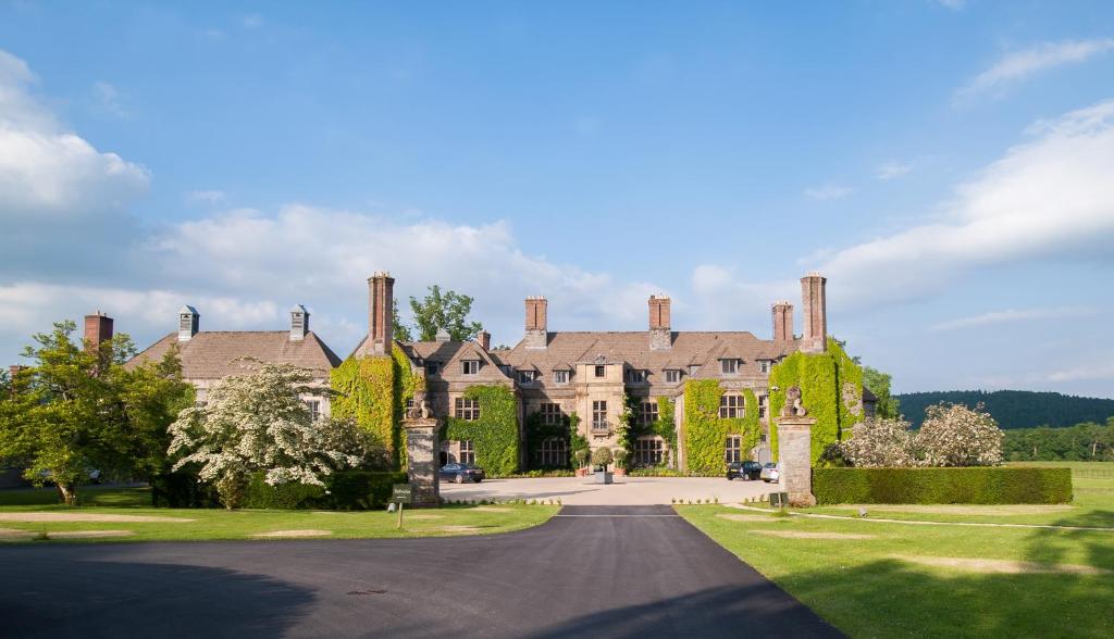 uma casa grande com uma entrada em frente em Llangoed Hall em Bronllys