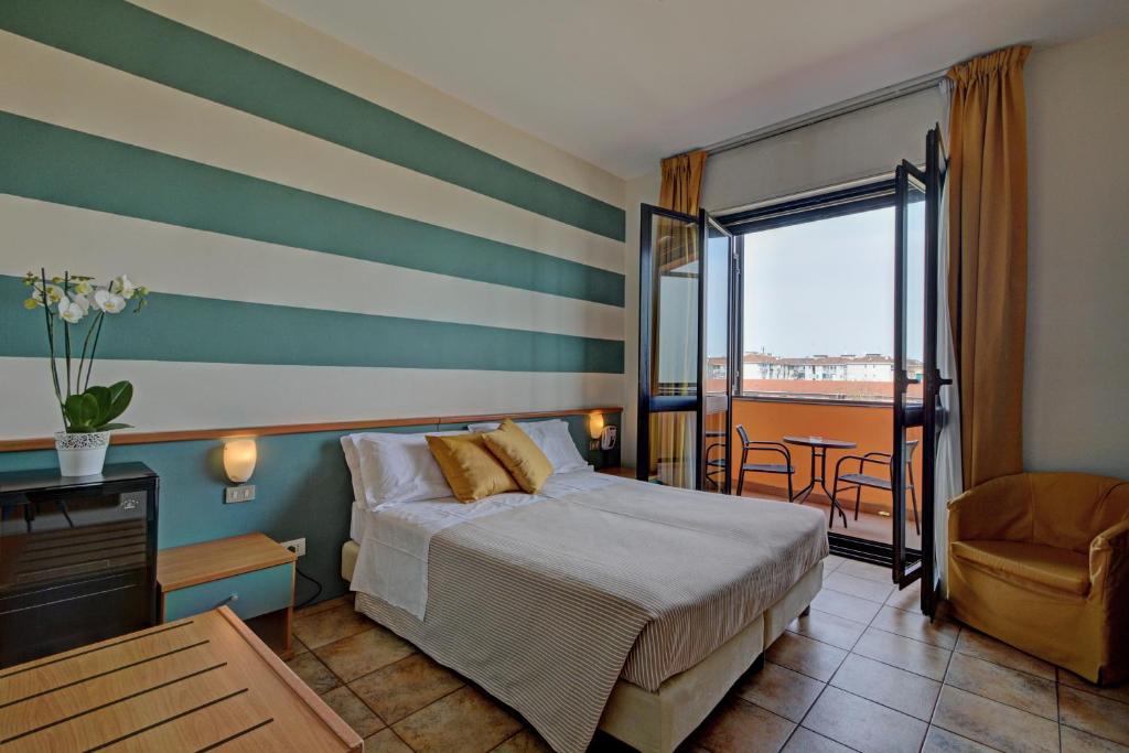 a hotel room with a bed and a balcony at Astor Hotel in Turin