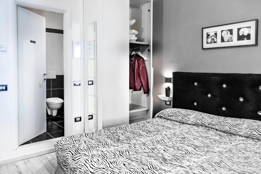 una camera da letto in bianco e nero con letto e bagno di B&B Flo a Firenze