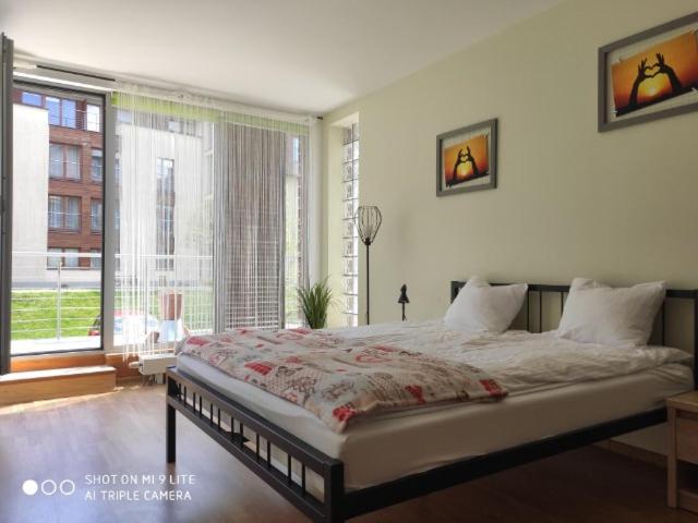 um quarto com uma cama grande e uma janela grande em LuxApartament 3 - z dużym tarasem i garażem w Zeta Park em Ustroń