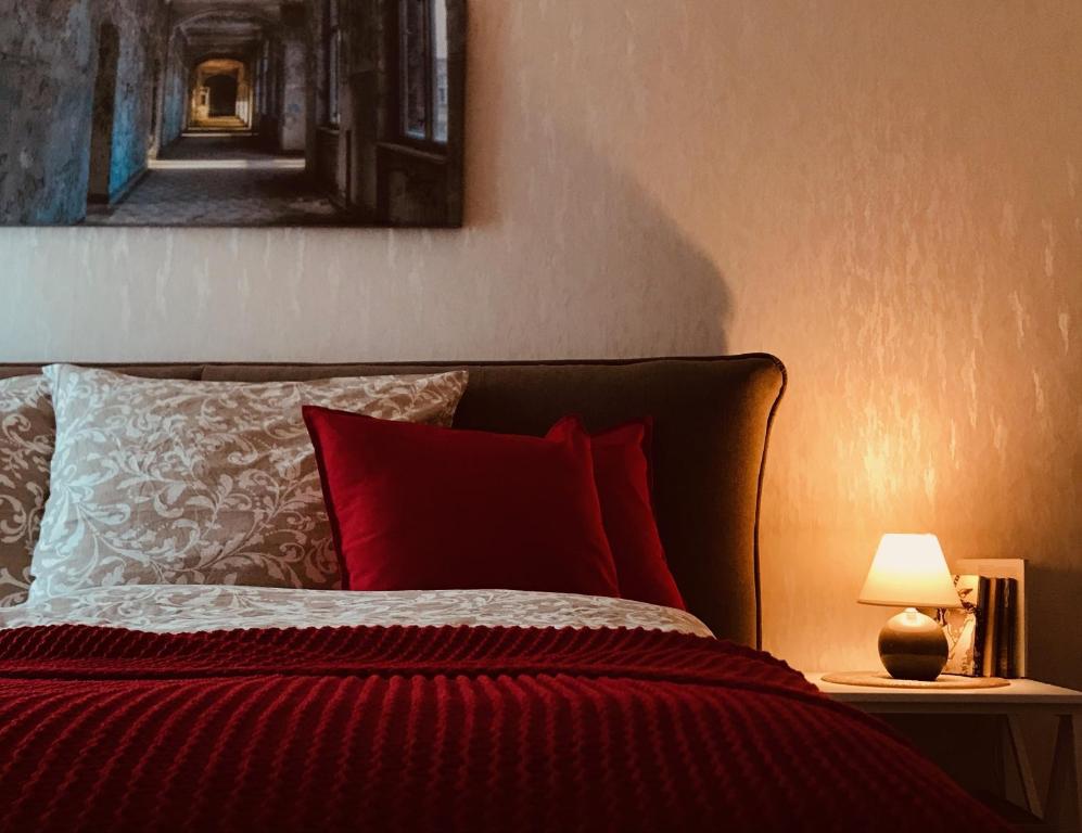 a bedroom with a bed with red pillows and a lamp at Ferienzimmer in Allensbach in Allensbach