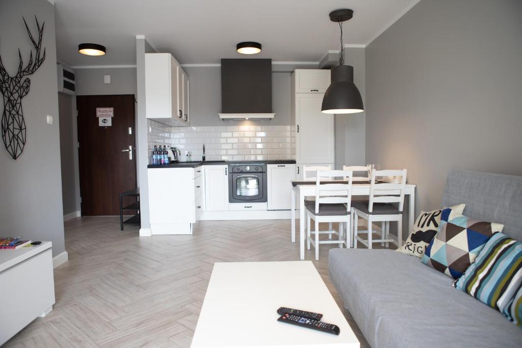 uma sala de estar e cozinha com um sofá e uma mesa em Apartament Scandic em Malbork