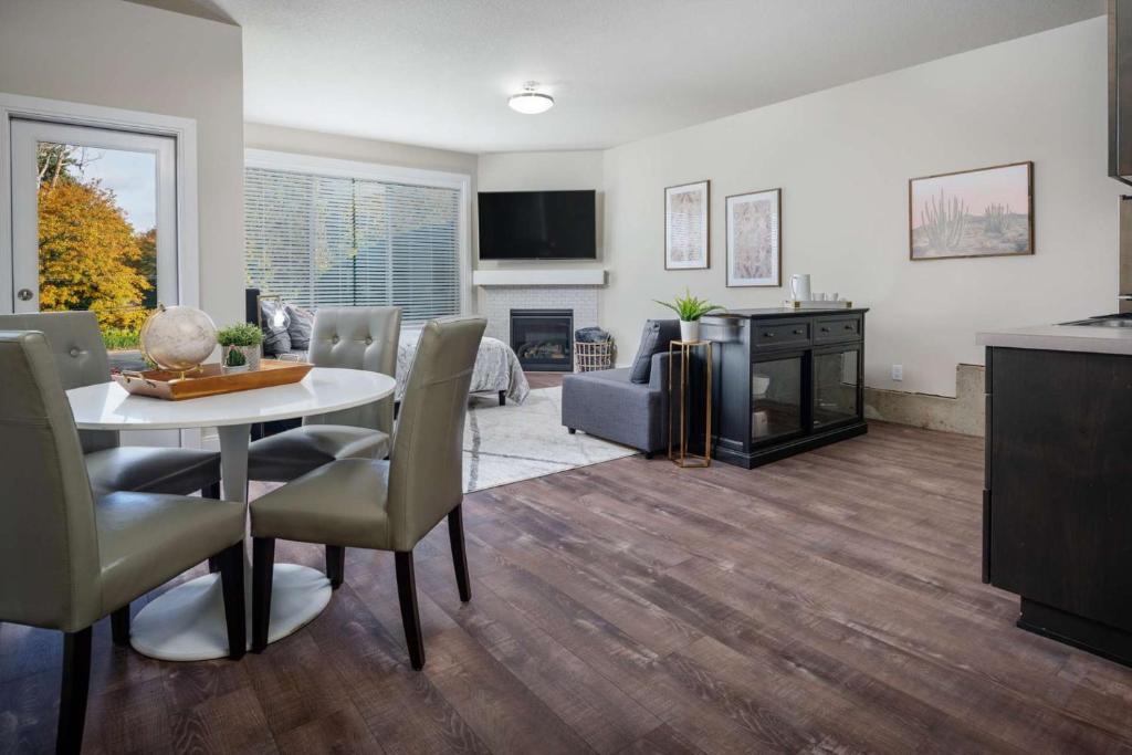 ein Wohnzimmer mit einem Tisch, Stühlen und einem Kamin in der Unterkunft Milwaukie Heights South Studio in Oak Grove
