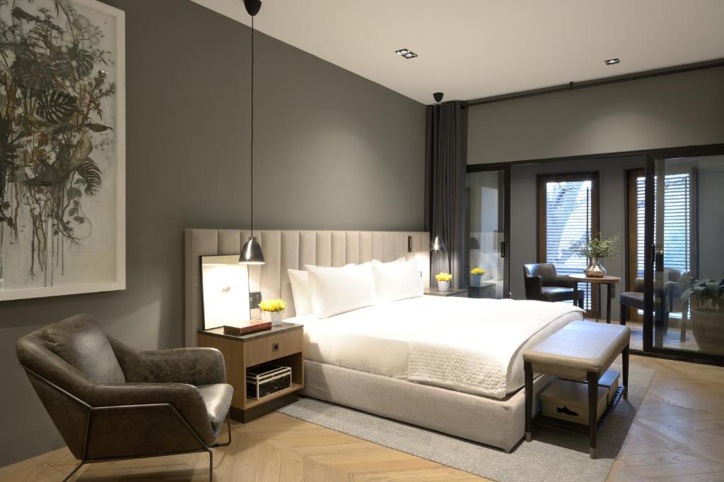 a bedroom with a king sized bed and a chair at Brick Hotel Mexico City - Small Luxury Hotels of the World in Mexico City