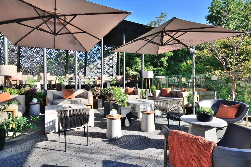 a patio with tables and chairs and umbrellas at Brick Hotel Mexico City - Small Luxury Hotels of the World in Mexico City