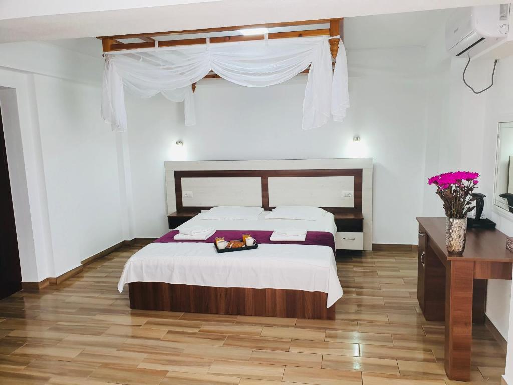 Schlafzimmer mit einem Bett und Holzboden in der Unterkunft Casa Barina Costinești in Costinești